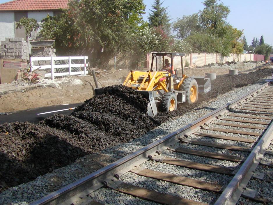 Construction equipment moving tire derived aggregate along rail tracks