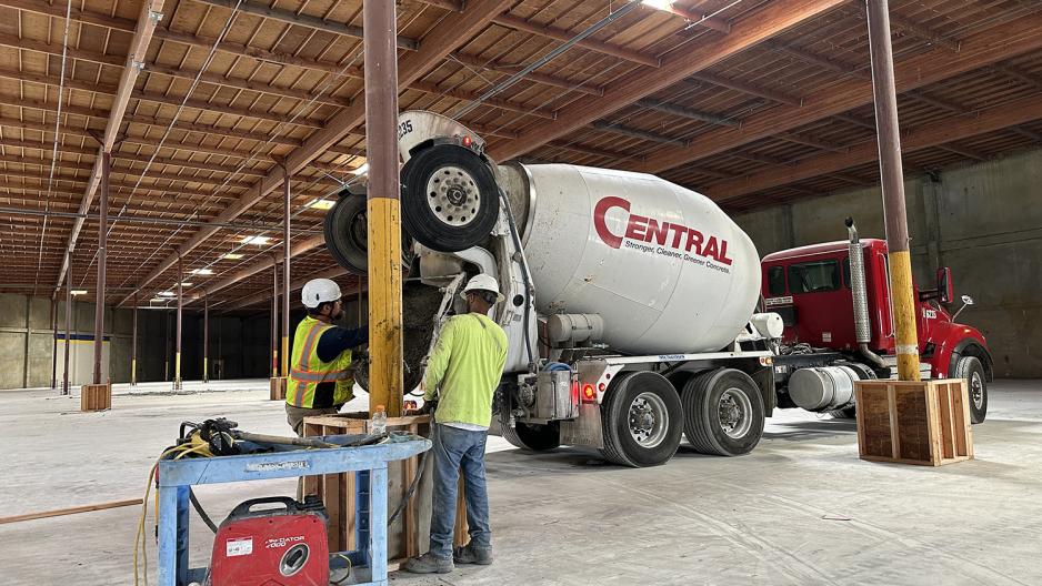 cement truck in use to reinforce the structure poles inside the parking garage. 