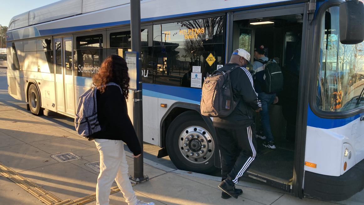 passengers step onto bus