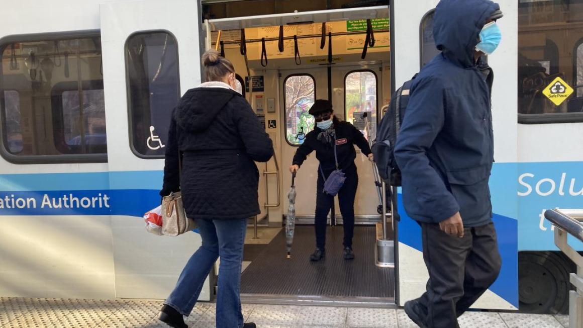 people getting on and off a light rail train