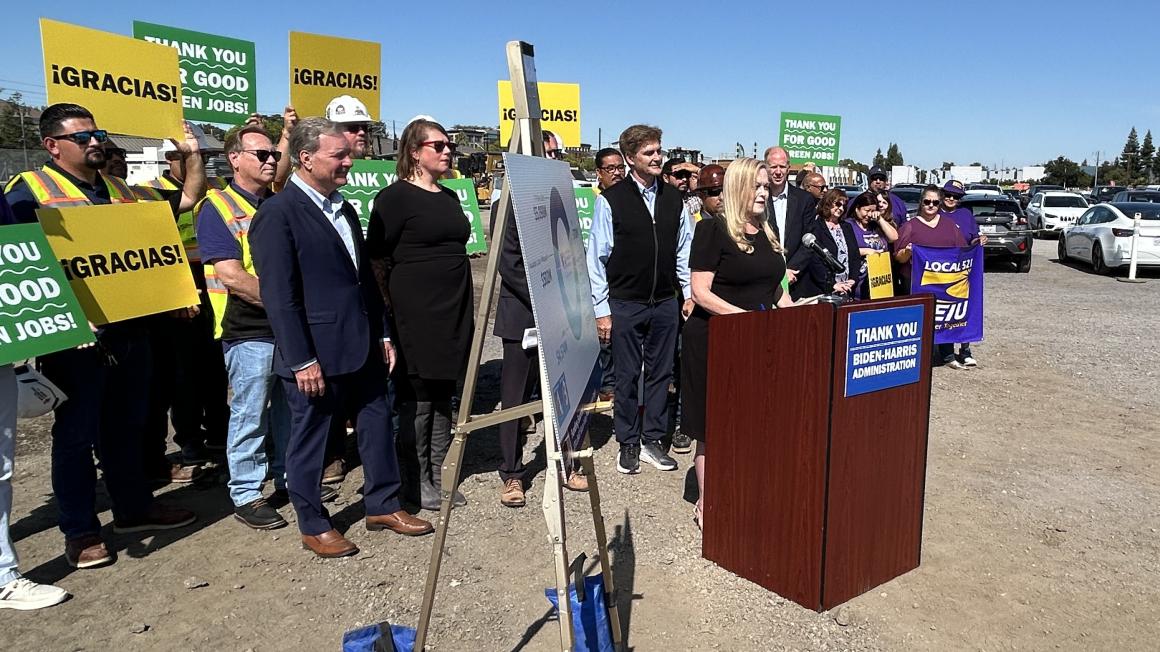 Cindy Chavez speaking at podium with supporters behind her