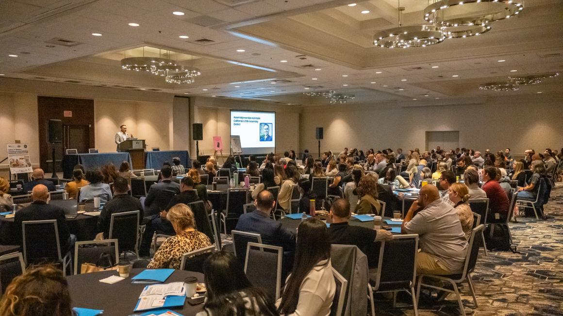 hundreds of people sitting in a conference room