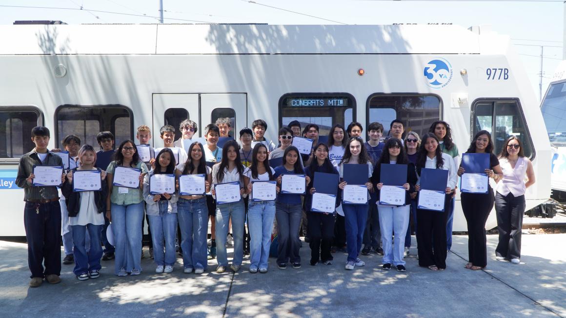 Mineta Transportation Institute summer program high school students' group photo with their certificates in front of the VTA light rail train