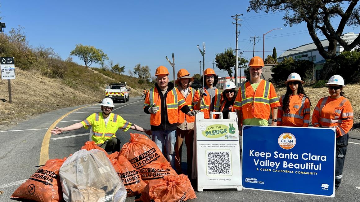 workers posing with trash bags after cleaning the freeway