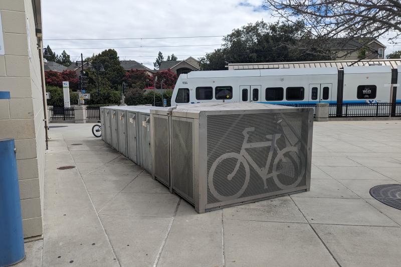 Bike lockers in front of train. 