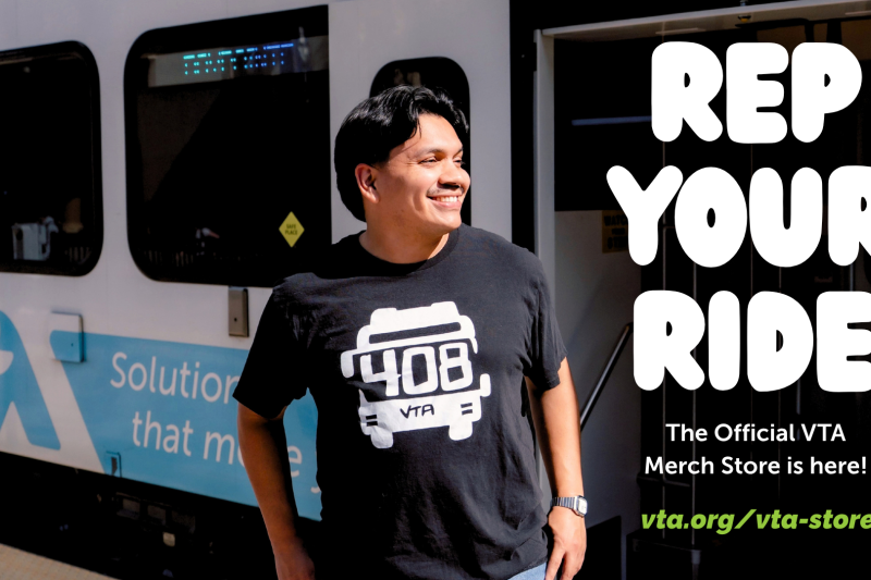 Rep your ride. The official VTA Merch Store is here! Male wearing 408 VTA bus black tshirt standing next to a light rail