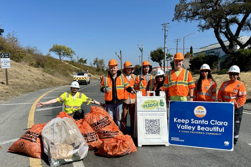 workers posing with trash bags after cleaning the freeway