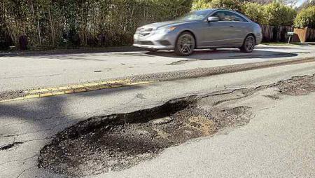 car driving by pot hole