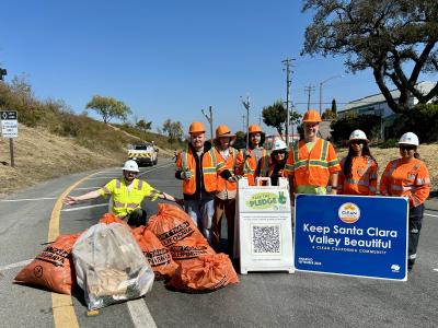 workers posing with trash bags after cleaning the freeway
