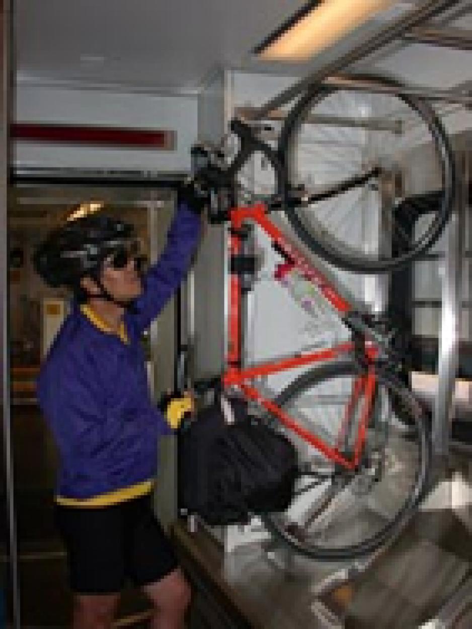 cyclist putting bike on light rail bike rack