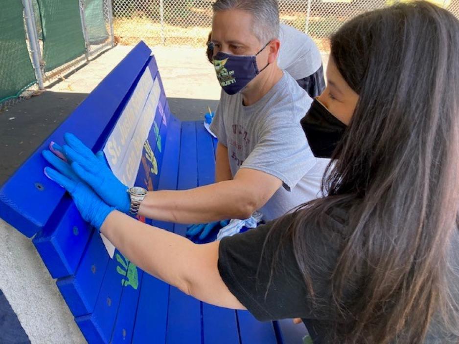 teacher places handprint on public art bench