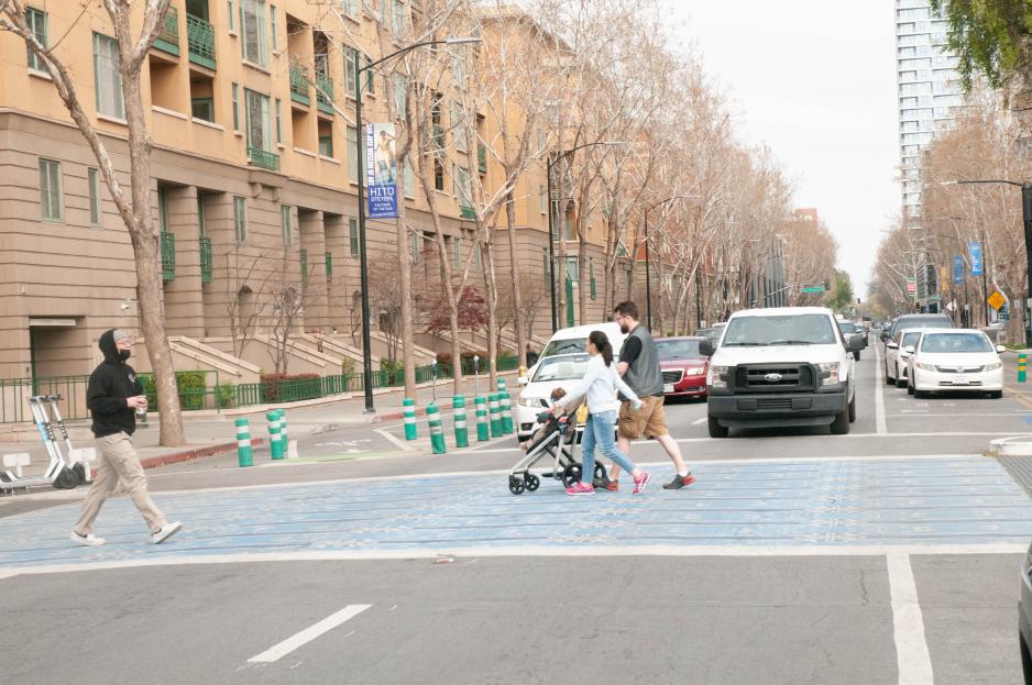 Photograph of decorative crosswalk in downtown San Jose. Cars are stopped and pedestrians are in the crosswalk.