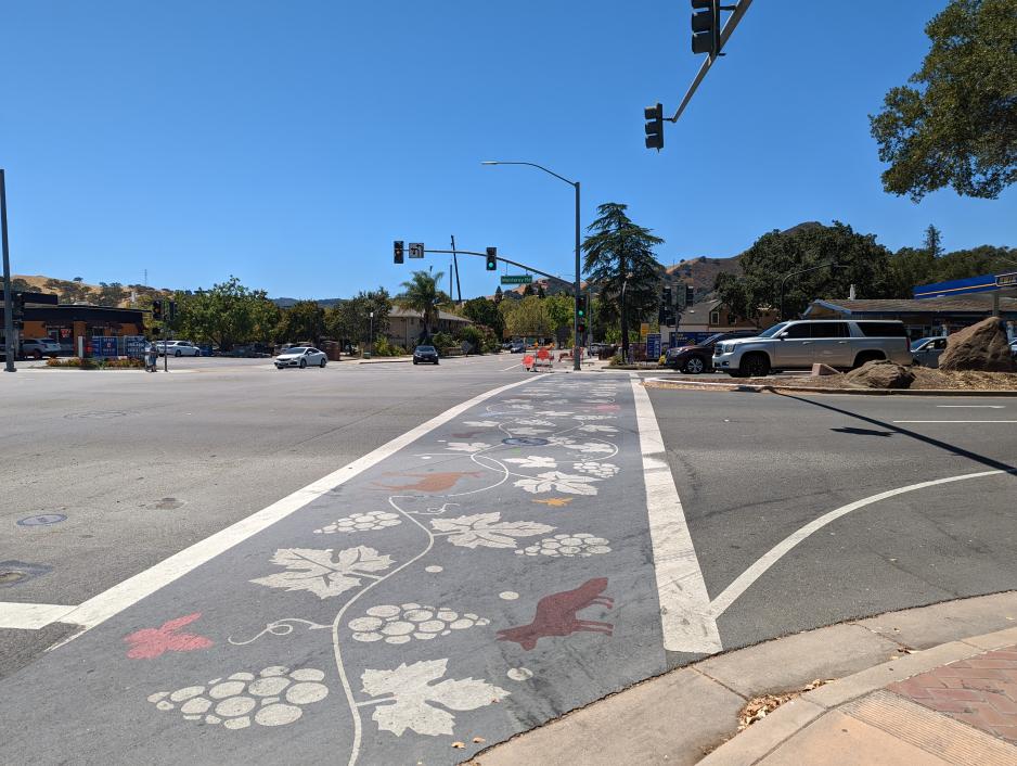 Photo showing a crosswalk painted with decorative stencils.