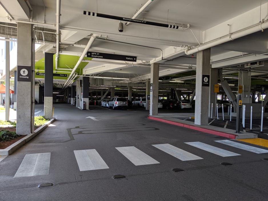 A photo of a parking garage with a pedestrain crosswalk.