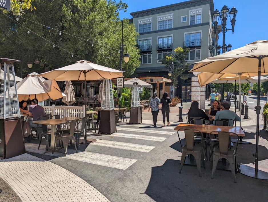 A photo of outdoor restaurant seating on a closed street in Santana Row. 