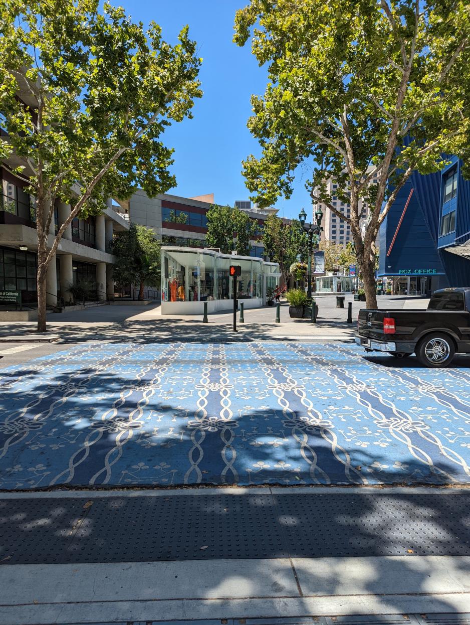 A photo of a mid-block colorful and wide crossing.