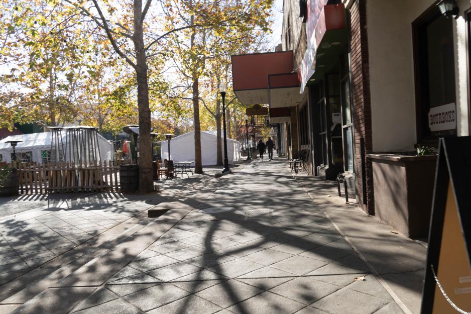 A photo of a sidewalk downtown with building canopies.