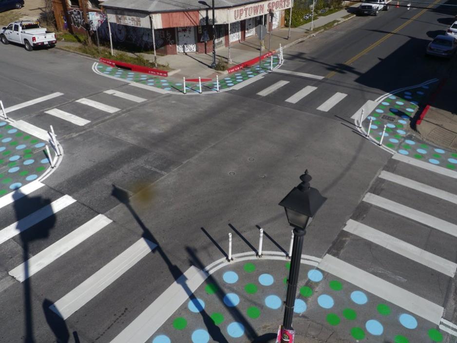 Photo showing painted curb extensions decorated with painted dots.