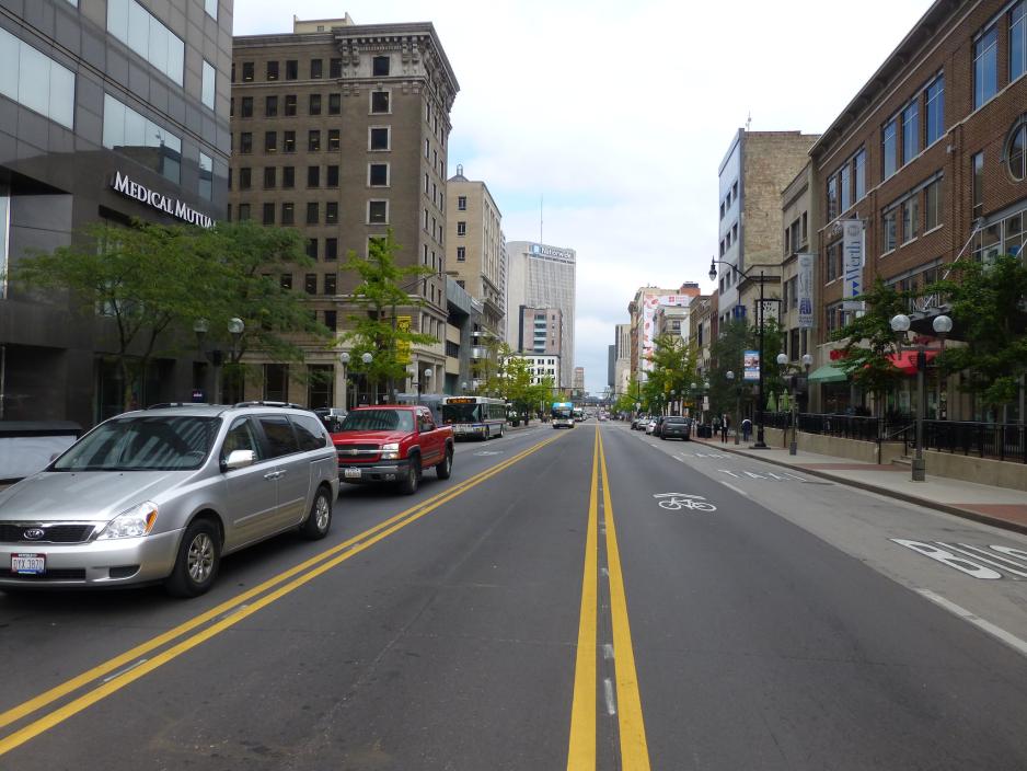 Photo of a commercial street with painted median to narrow travel lanes.