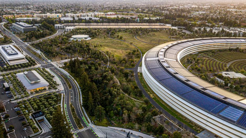 An aerial photo of an surface level parking with an underground parking garage at Apple Park.