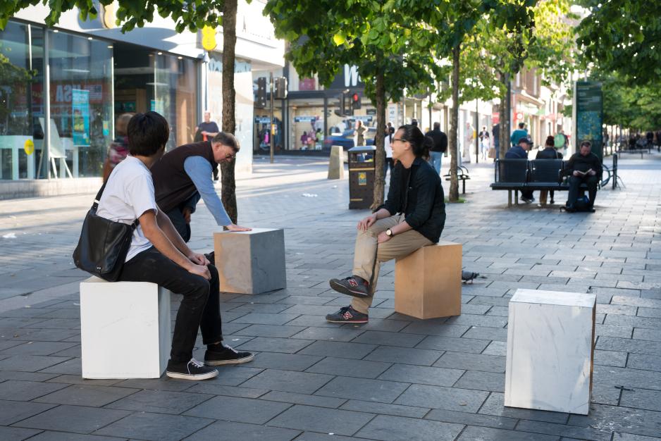 A photo of people sitting on flexible block seating.