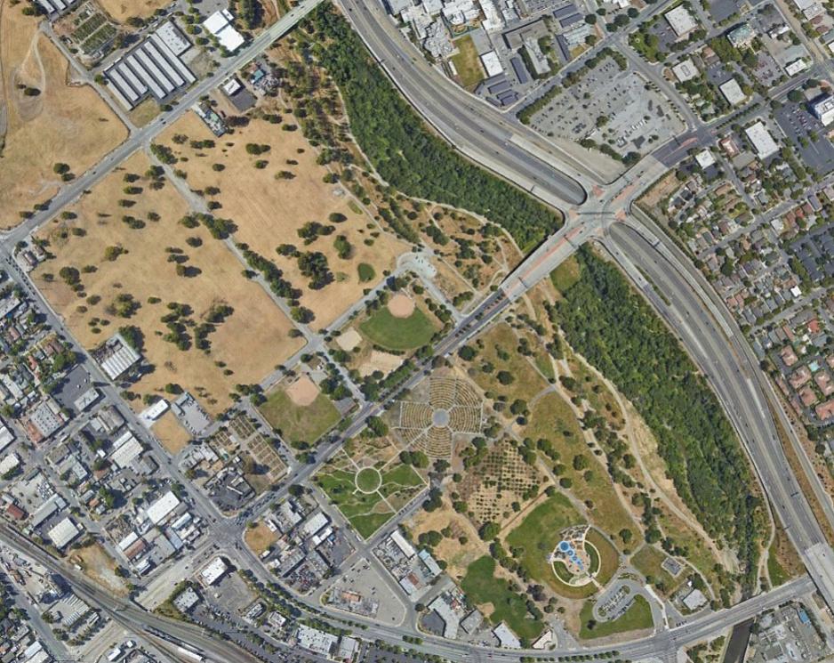 An aerial photo of a trail next to a freeway and development. 