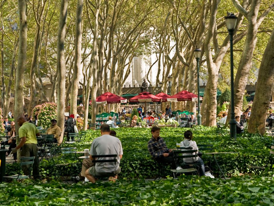 A photo of plaza with tables and chairs near an outdoor cafe.