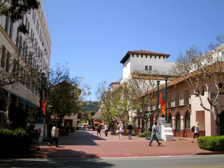 A photo of a people walking a commercial plaza. 