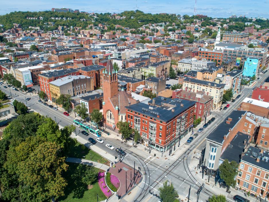 A photo of a downtown area with a park and mid-size buildings. 