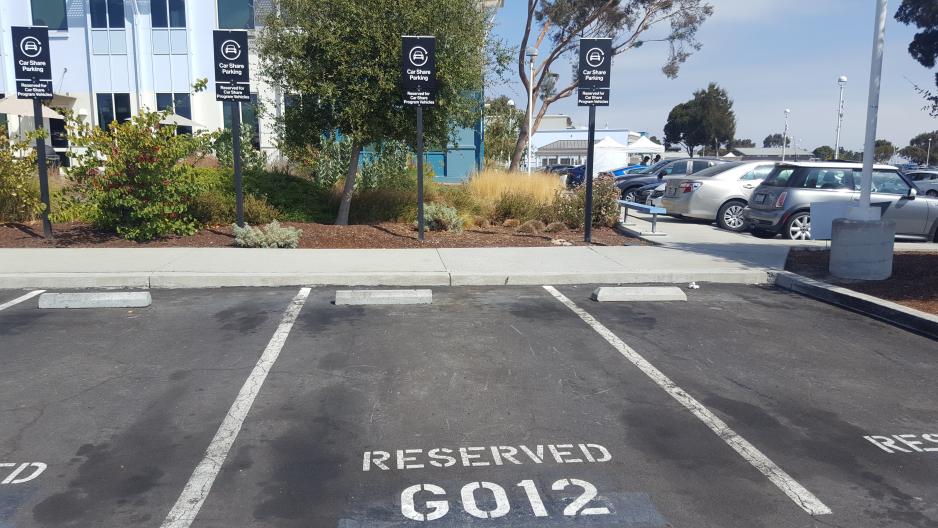 Photo of reserved carpool parking spaces in front of a building and landscaping