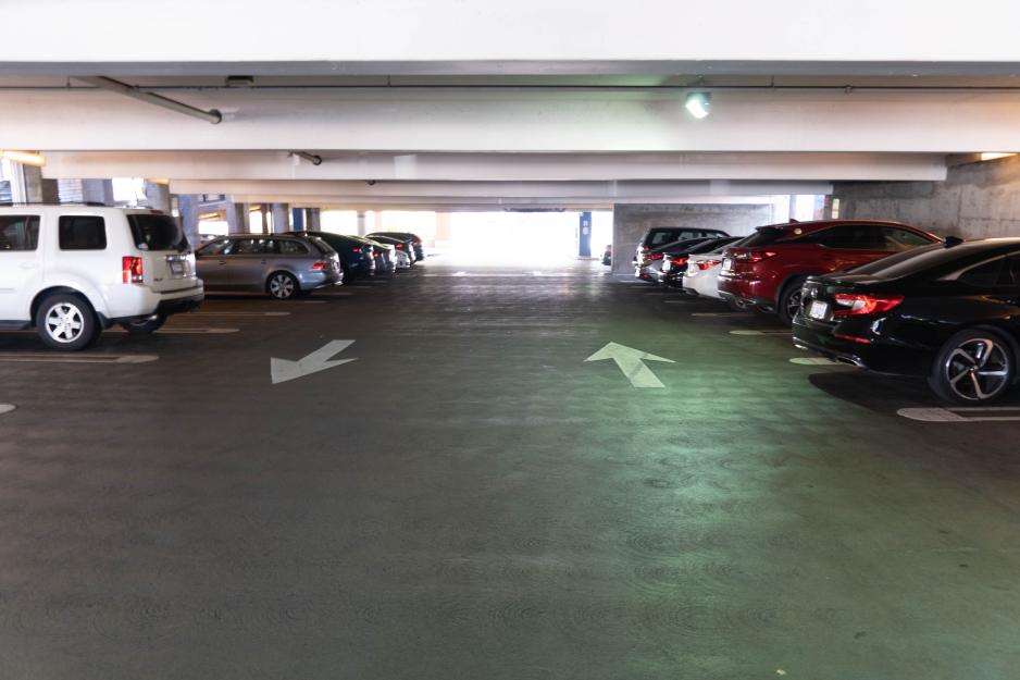 Photo of parking garage with cars parked on both sides of the aisle