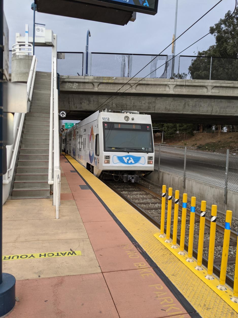 A photo of a light rail station with a train arriving.