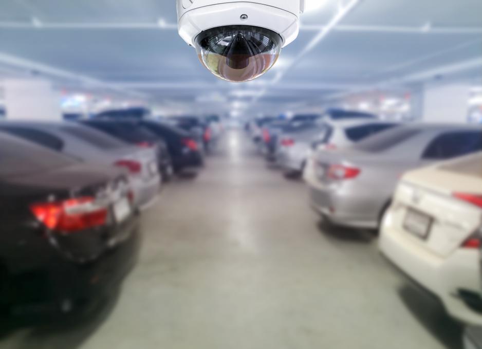 Photo of a camera above parked vehicles in a parking garage