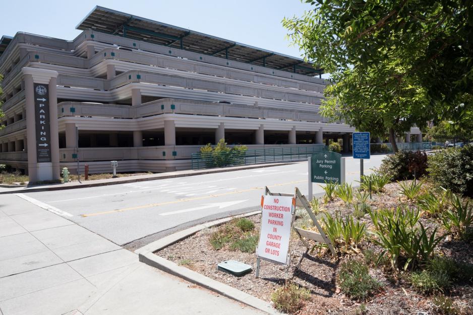 Photo of entrance to a parking garage with wayfinding signage and landscaping