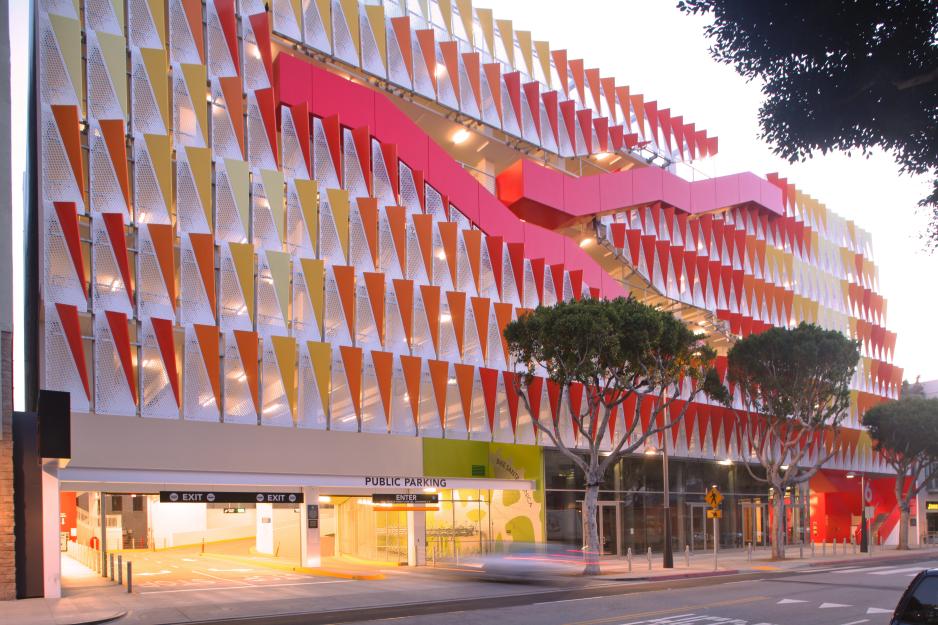 Photo of taller colorful parking garage with entrances and exits and shops on the bottom floor