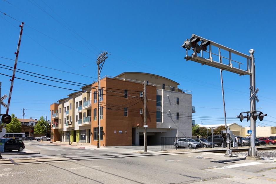 Photo of taller building with railroad track crossing in front