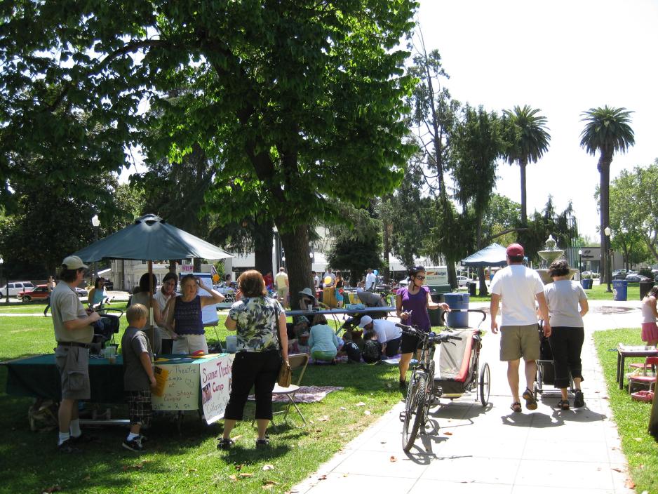 Photo of people walking around a park during an event with booths