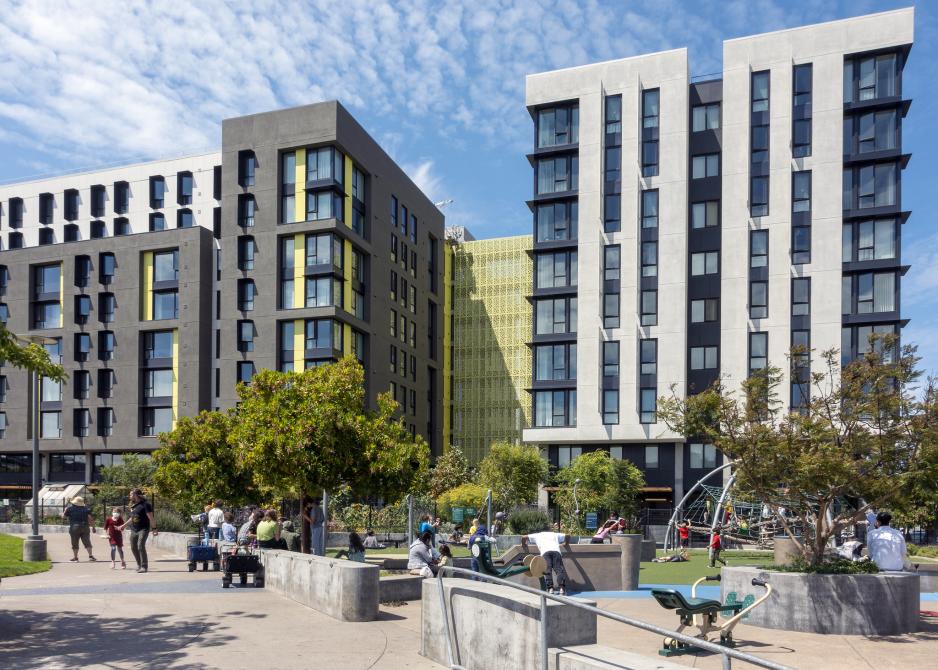 An illustration of people playing at a playground next to a mixed-use development.