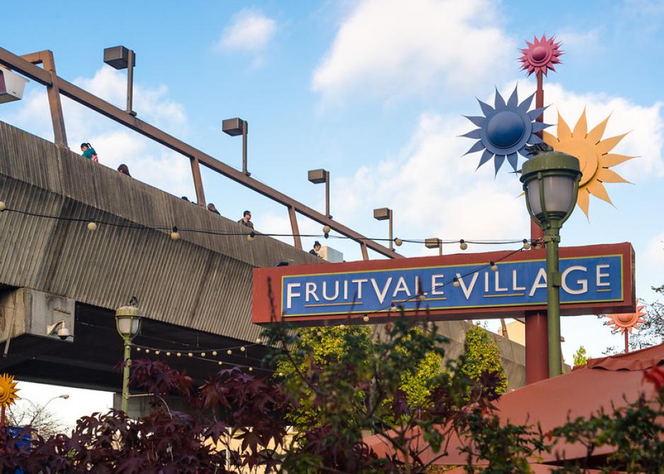 A photo of the Fruitdale Station sign with the elevated station.
