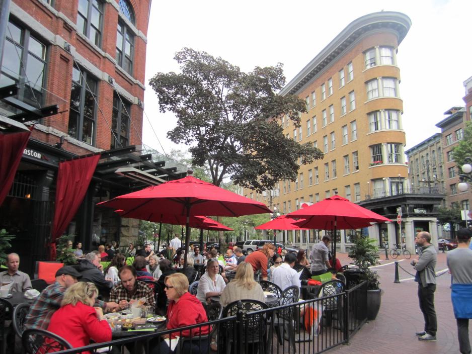 A photo of a packed restaurant patio in a commercial center.