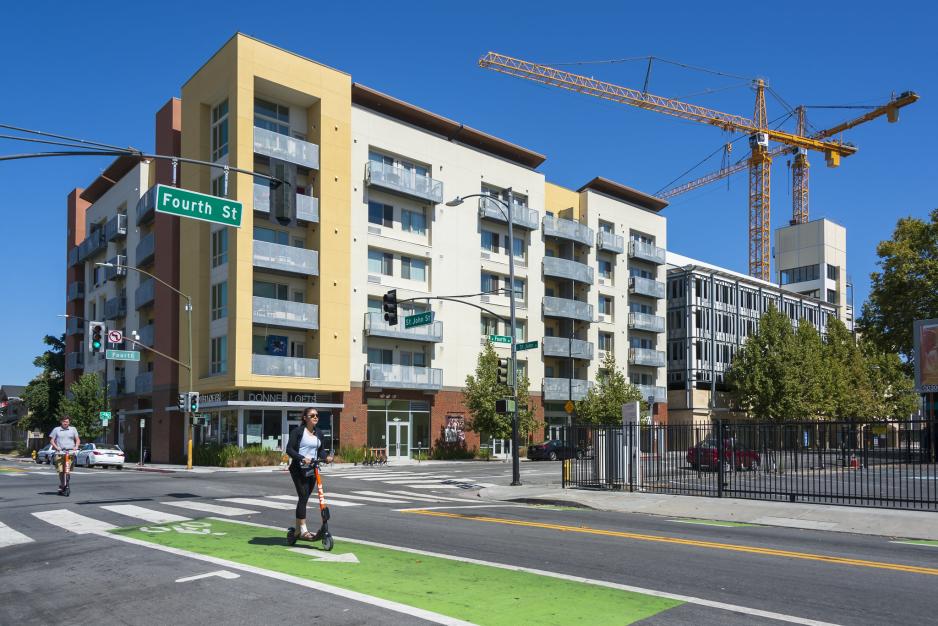 A photo of an apartment complex and a separated bike lane on the street.