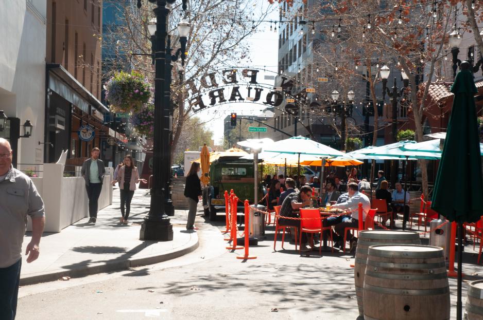 A photo of a main street closed to cars with restaurant seating. 