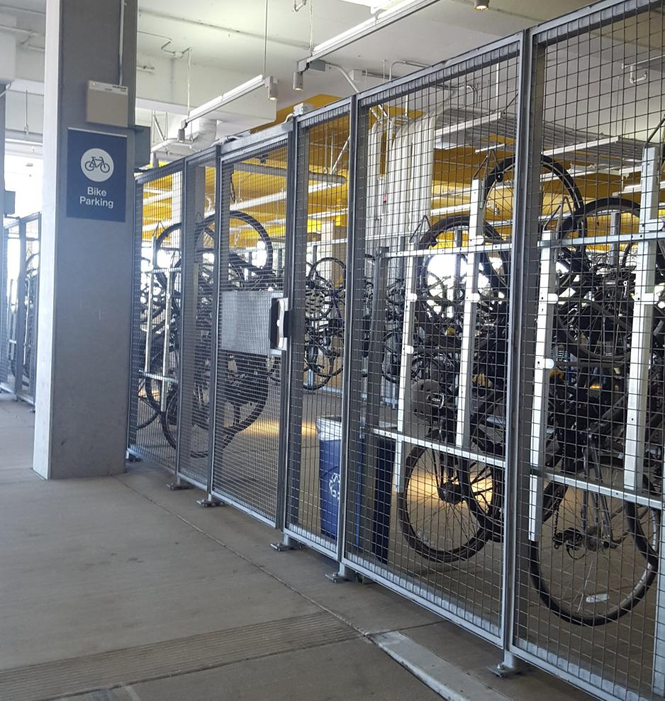 A photo of an enclosed bike parking area within a parking garage. 