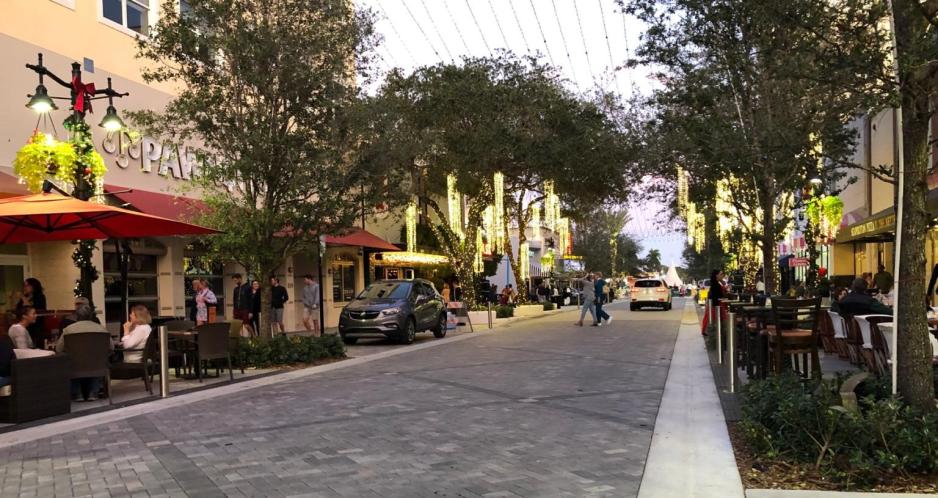 A picture of a shared street with cafe seating on the sides.