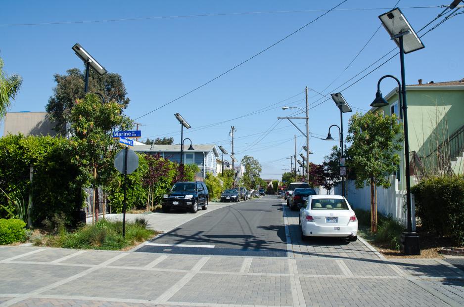 A photo of a street with parking on both sides and a crosswalk at the intersection.