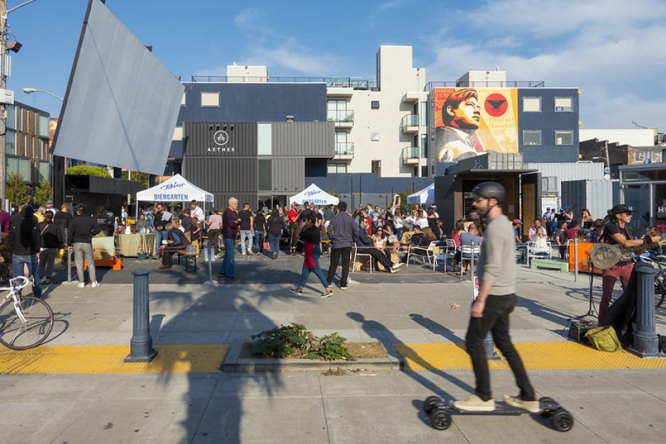 Photo of skateboarder in front of street party in front of apartment building