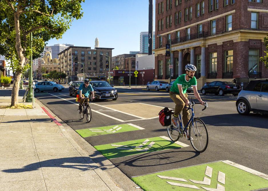 A photo of a street with a green bike lane.