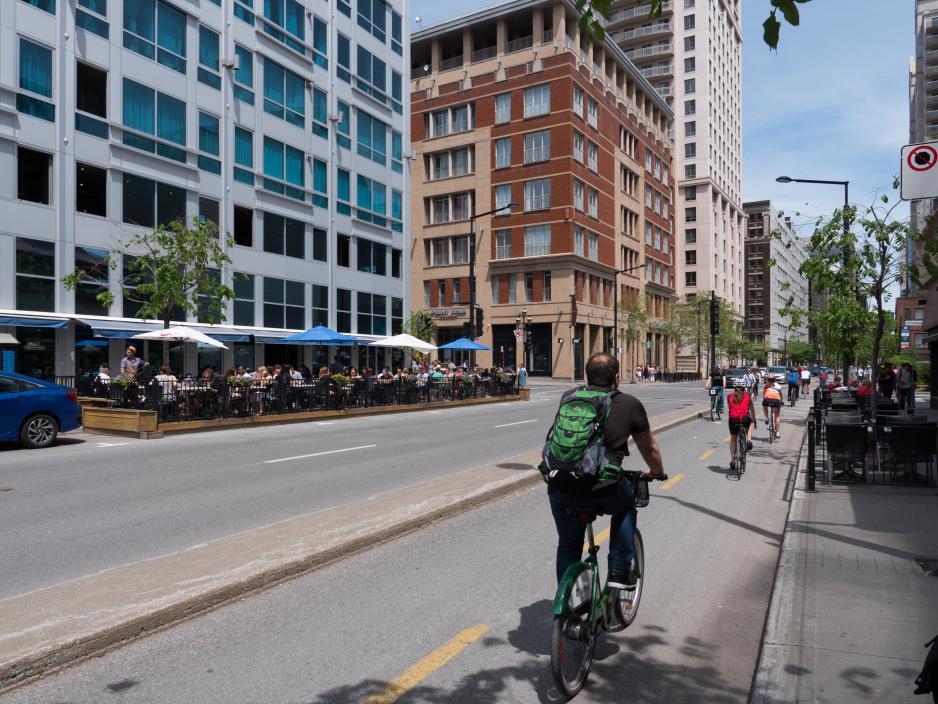 A photo of a separated 2-way bike lanes next to a downtown-like area. 
