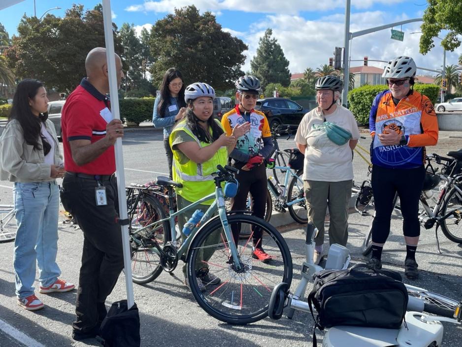 bicyclists listening to woman speaking