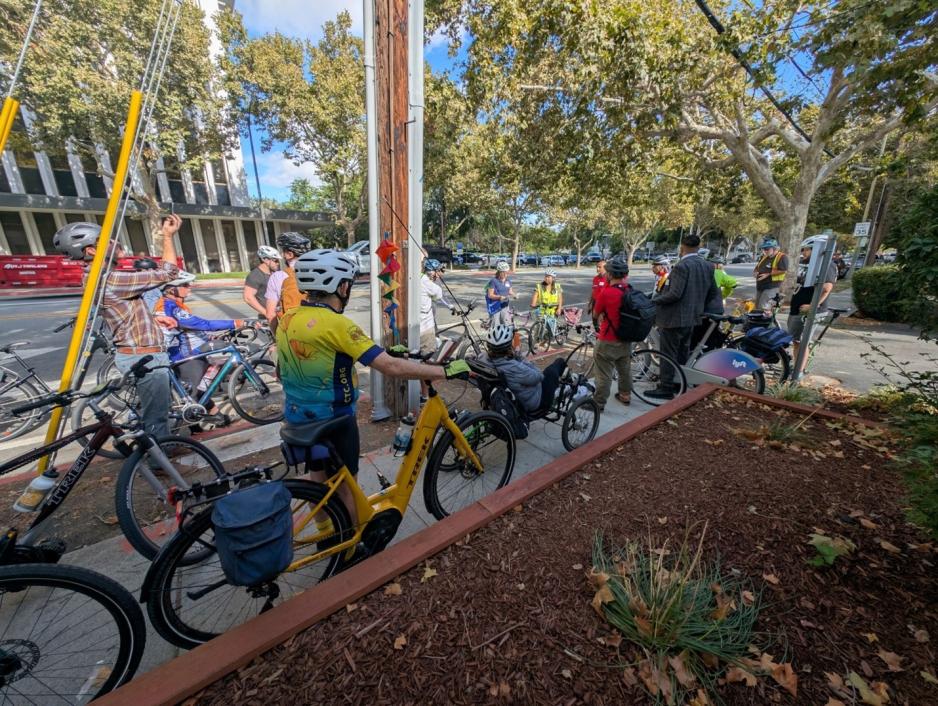 bicylists gathered on El Camino Real sidewalk